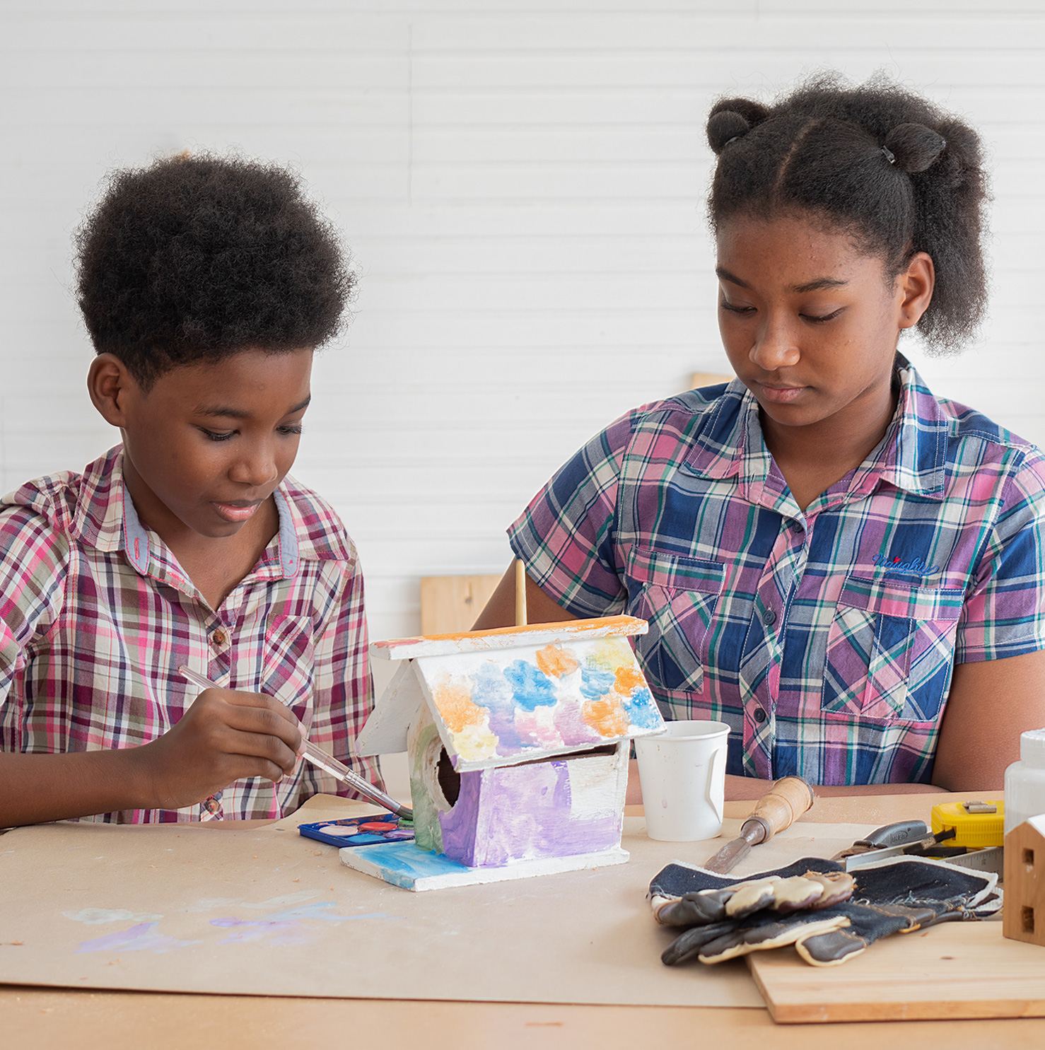 two children painting birdhouse